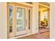 Elegant front door featuring glass panels and an inviting view of the front porch with comfortable seating at 11986 Granite Woods Loop, Venice, FL 34292