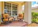 Inviting front porch with brick flooring, comfortable seating, and view of the neighborhood at 11986 Granite Woods Loop, Venice, FL 34292