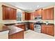 This is a full view of the Kitchen featuring stainless steel appliances and cherry wood cabinets at 11986 Granite Woods Loop, Venice, FL 34292