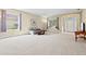 Bright, open living room showcasing large windows, comfortable seating, and neutral carpeting at 11986 Granite Woods Loop, Venice, FL 34292