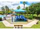 Community playground featuring modern blue play structures, sunshade, and soft ground cover, offering a fun and safe environment at 11986 Granite Woods Loop, Venice, FL 34292
