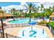 Resort-style pool area with lounge chairs, umbrellas, and a splash pad for children in a tropical setting at 11986 Granite Woods Loop, Venice, FL 34292