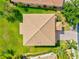 Aerial view showcasing the tile roof of a home, surrounded by a green lawn and mature trees at 11986 Granite Woods Loop, Venice, FL 34292