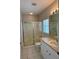 Bathroom with white cabinets, tile floors, and glass enclosed shower at 1204 L Pavia Blvd # 1204, Venice, FL 34292