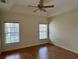 Bright bedroom features wood floors, two windows, ceiling fan and tray ceiling at 1204 L Pavia Blvd # 1204, Venice, FL 34292