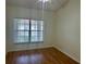 Cozy bedroom featuring wood flooring, a ceiling fan, and a bright window view at 1204 L Pavia Blvd # 1204, Venice, FL 34292