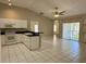 Open kitchen with white cabinets and appliances, bar seating, tile floor, and lots of natural light at 1204 L Pavia Blvd # 1204, Venice, FL 34292