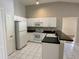 A bright white kitchen with stainless steel appliances, ample cabinets, and convenient breakfast bar seating at 1204 L Pavia Blvd # 1204, Venice, FL 34292
