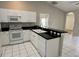 Bright kitchen with white cabinets, stainless steel appliances, and a breakfast bar perfect for casual dining at 1204 L Pavia Blvd # 1204, Venice, FL 34292