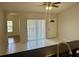 Bright living room featuring tile flooring, a ceiling fan, and sliding glass doors for ample natural light at 1204 L Pavia Blvd # 1204, Venice, FL 34292