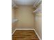 Walk-in closet featuring wood-look flooring and ample shelving for organization at 1204 L Pavia Blvd # 1204, Venice, FL 34292