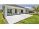 An expansive white concrete patio and landscaped backyard of the home at 1228 Pineland Ave, Venice, FL 34285