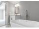 Bright bathroom featuring a soaking tub, modern faucet, vanity, and natural light at 1228 Pineland Ave, Venice, FL 34285