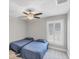 Bedroom features two twin beds, a ceiling fan, and neutral decor at 1228 Pineland Ave, Venice, FL 34285