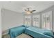 Cozy bedroom with two twin beds, a ceiling fan, and natural light at 1228 Pineland Ave, Venice, FL 34285
