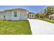 Exterior view of home with clean, white driveway and lawn at 1228 Pineland Ave, Venice, FL 34285