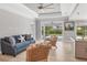 Bright living room featuring tray ceilings, ceiling fan, and access to the outdoor patio at 1228 Pineland Ave, Venice, FL 34285