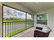 Inviting screened-in balcony with comfortable chairs and picturesque views of the golf course and lake at 12390 Wellen Golf St # 203, Venice, FL 34293