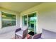 Comfortable balcony featuring wicker chairs and a golf course view through sliding glass doors at 12390 Wellen Golf St # 203, Venice, FL 34293