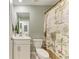 Bathroom boasts a vanity with modern fixtures, decorative shower curtain and toilet at 12390 Wellen Golf St # 203, Venice, FL 34293