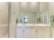 Clean bathroom featuring a double vanity, framed mirrors, and a glass door shower at 12390 Wellen Golf St # 203, Venice, FL 34293