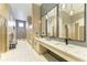 Modern bathroom featuring multiple sinks, large mirrors, and stylish lighting fixtures at 12390 Wellen Golf St # 203, Venice, FL 34293