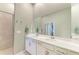 Bright bathroom with a dual sink vanity, a framed mirror, and a glass-enclosed shower at 12390 Wellen Golf St # 203, Venice, FL 34293