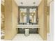 Clean bathroom featuring double sinks, modern lighting, and convenient shower access at 12390 Wellen Golf St # 203, Venice, FL 34293