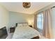 Bedroom features a ceiling fan, side tables with lamps, and a large window at 12390 Wellen Golf St # 203, Venice, FL 34293