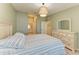 Inviting bedroom with dresser, window, a soft bed, and an overhead light fixture at 12390 Wellen Golf St # 203, Venice, FL 34293