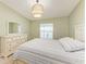 Relaxing bedroom with a dresser, a soft bed, a window, and a modern light fixture at 12390 Wellen Golf St # 203, Venice, FL 34293