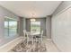 Cozy dining area features a round table, white chairs, natural light, and neutral decor at 12390 Wellen Golf St # 203, Venice, FL 34293