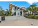 Stunning exterior view of The Banyan House featuring large windows and tropical landscaping at 12390 Wellen Golf St # 203, Venice, FL 34293