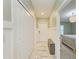 Hallway with multiple closets, a bench, and tiled floors leading to a bedroom at 12390 Wellen Golf St # 203, Venice, FL 34293