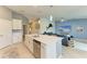 Bright kitchen with stainless steel appliances, white cabinetry, and an island with a sink at 12390 Wellen Golf St # 203, Venice, FL 34293