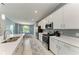 Modern kitchen with stainless steel appliances, white cabinetry, and a large island with a sink at 12390 Wellen Golf St # 203, Venice, FL 34293