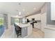 A modern kitchen with stainless steel appliances, white cabinets, and a large island with barstool seating at 12390 Wellen Golf St # 203, Venice, FL 34293