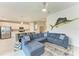 Bright living room with a large sectional couch, ceiling fan, and views into the kitchen at 12390 Wellen Golf St # 203, Venice, FL 34293