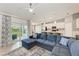The open-concept living room features a comfortable sectional sofa and sliding glass doors to the outdoor living space at 12390 Wellen Golf St # 203, Venice, FL 34293