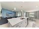 Open-concept living space featuring a kitchen with an island and a living room with a mounted television at 12390 Wellen Golf St # 203, Venice, FL 34293