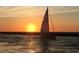 Sailboat sailing into a stunning sunset providing a serene and picturesque scene at 12390 Wellen Golf St # 203, Venice, FL 34293