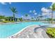 Beautiful swimming pool showcasing its expansive size, with inviting lounge areas, palm trees and lush landscaping at 12390 Wellen Golf St # 203, Venice, FL 34293