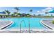 A refreshing community swimming pool with clear blue water, surrounded by lush landscaping and inviting lounge areas at 12390 Wellen Golf St # 203, Venice, FL 34293