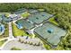 Aerial shot showcasing multiple tennis courts and a clubhouse with ample parking at 12390 Wellen Golf St # 203, Venice, FL 34293