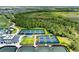Overhead view of tennis and pickleball courts surrounded by lush greenery and community buildings at 12390 Wellen Golf St # 203, Venice, FL 34293
