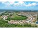 Scenic aerial view of a suburban community featuring a circular layout with houses and green spaces at 12871 Cinqueterre Dr, Venice, FL 34293