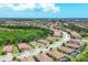 An aerial view shows the community's single-Gathering homes, landscaping, and street layout on a sunny day at 12871 Cinqueterre Dr, Venice, FL 34293