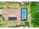 Aerial view of a home showcasing a screened-in pool, solar panels, and well-manicured landscaping at 12871 Cinqueterre Dr, Venice, FL 34293