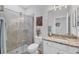 Bathroom features a tiled shower, modern vanity with a granite top, and artwork at 12871 Cinqueterre Dr, Venice, FL 34293