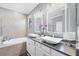 Spa-like bathroom with dual vessel sinks, soaking tub, and modern fixtures at 12871 Cinqueterre Dr, Venice, FL 34293